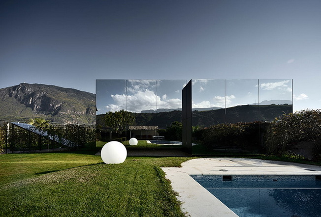 Casas espejadas que reflejan colinas paisajísticas